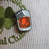 Jamo Please enamel pin on a hat, featuring Jameson Irish Whiskey design, ideal for St. Patrick's Day.