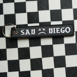Show off your emo side with this Sad Diego woven keychain. 