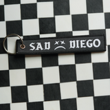Show off your emo side with this Sad Diego woven keychain. 