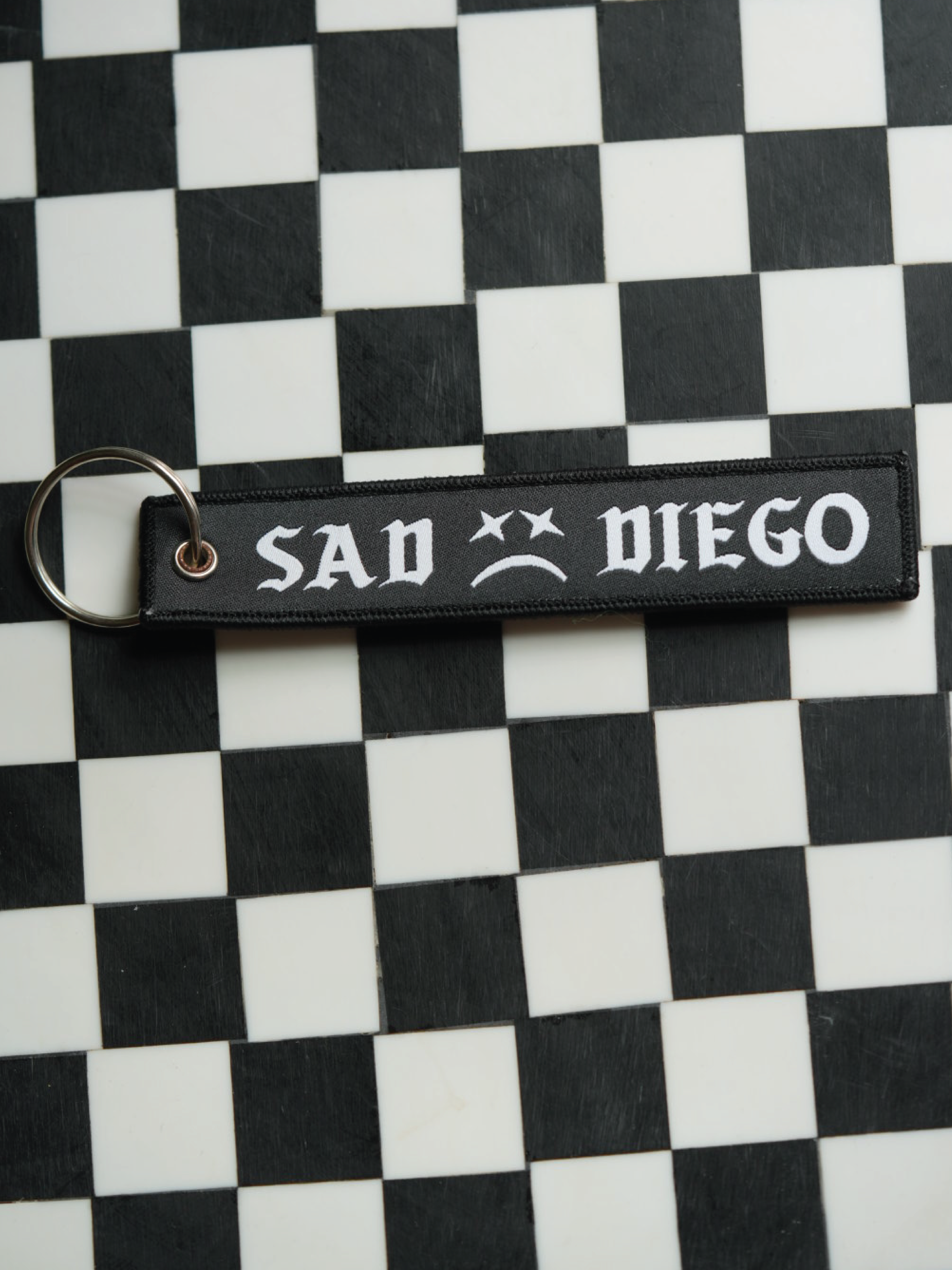 Show off your emo side with this Sad Diego woven keychain. 