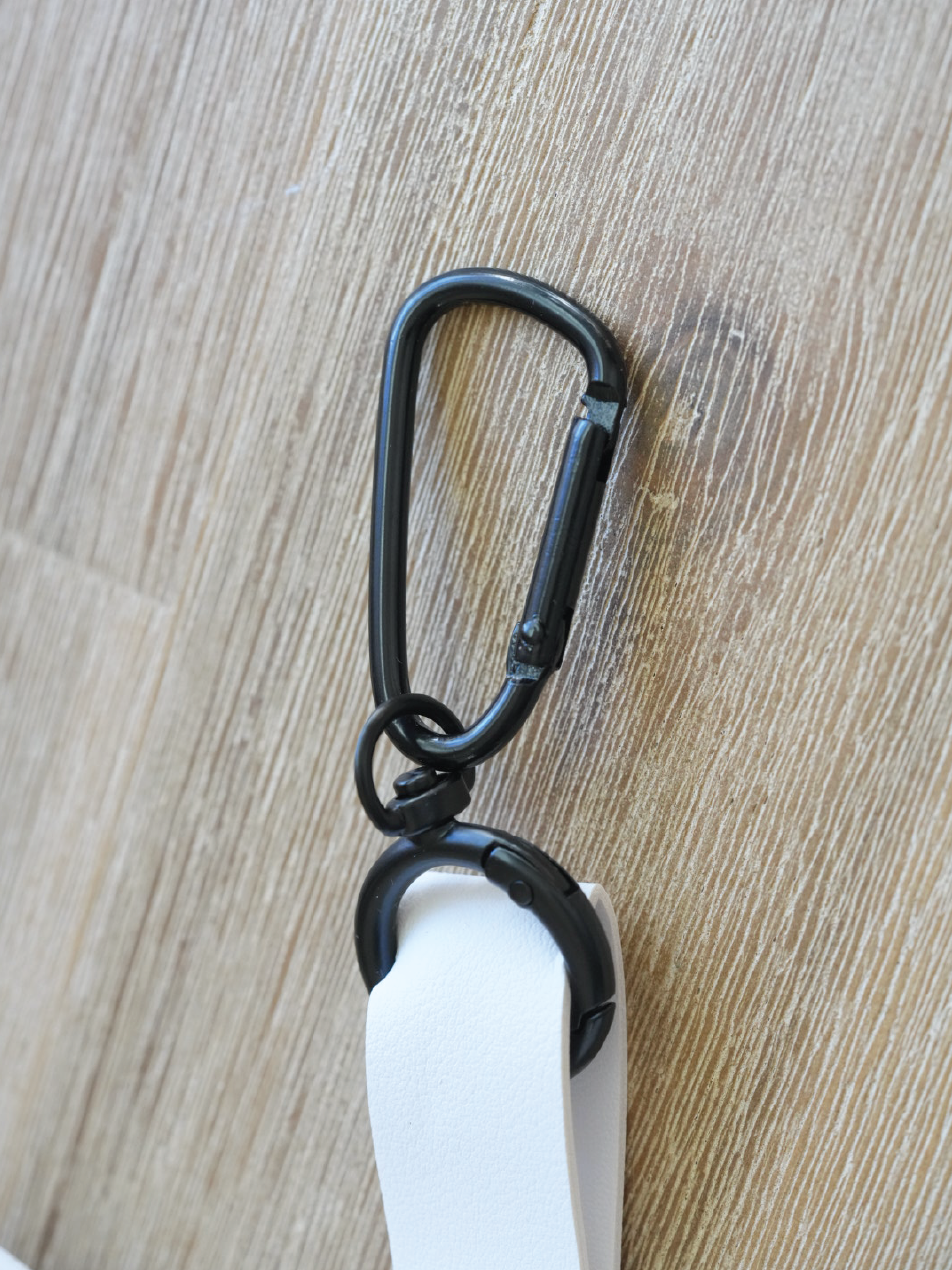 Close-up of the Moxxie White Leather Poop Bag Pouch’s durable matte black hook – perfect for easily attaching to your leash or purse!