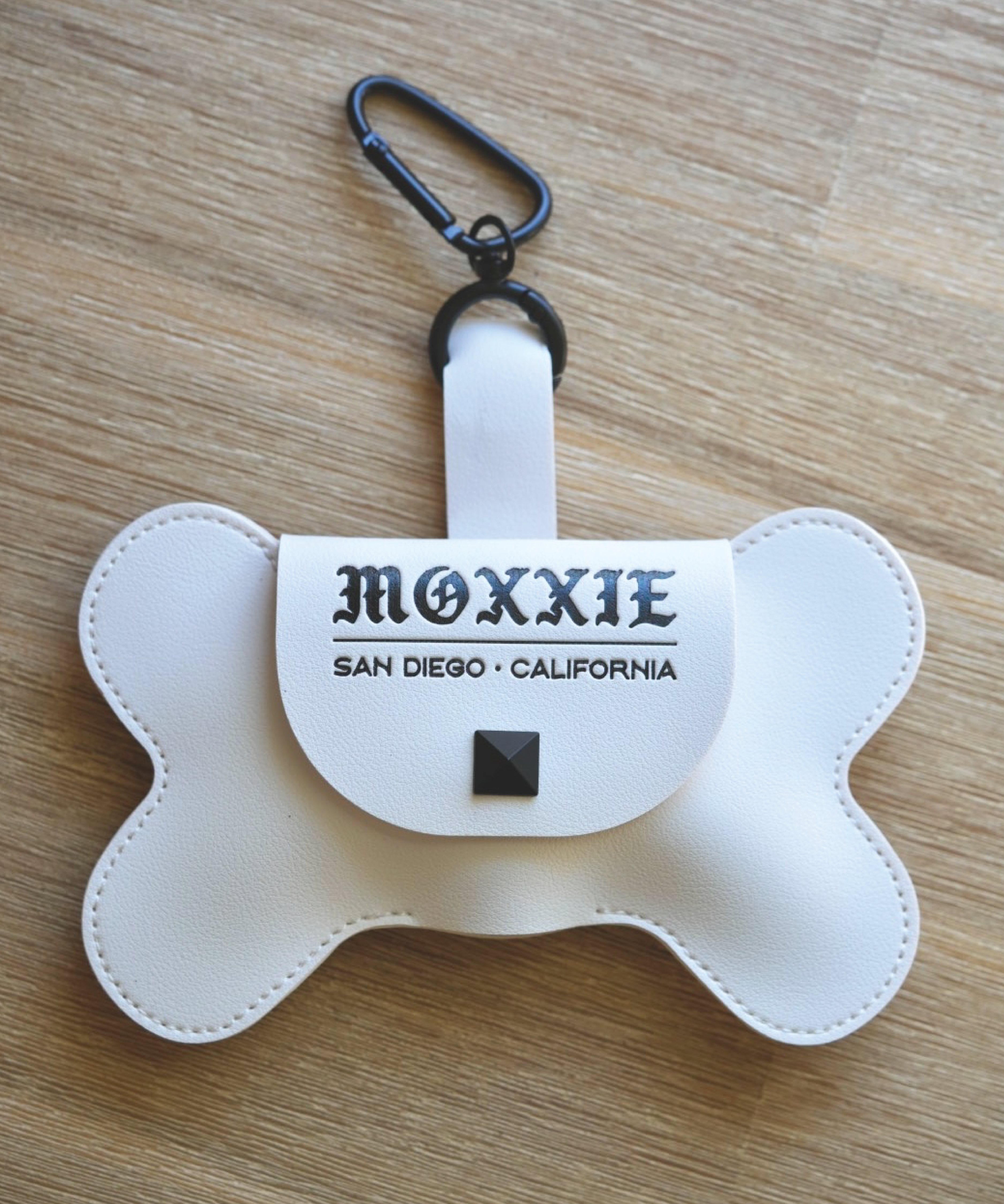 Compact and convenient, the Moxxie White Leather Poop Bag Pouch is designed for easy bag retrieval and replacement, with stylish matte black details.