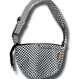 A small dog carrier sling in black and white checkers, designed for hands-free travel and walking. This adjustable, soft, and secure puppy carrier fits dogs and cats weighing 3-10 pounds.