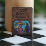 For spooky babes and horror lovers, this Beetlegeuse pin with the Handbook for the Recently Deceased is a must-have accessory.