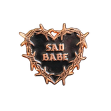 Embrace your sad girl vibes with this Sad Babe pin, featuring a barbed wire heart and classic tattoo art.