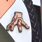 This Wednesday Addams pin set adds a touch of horror to your Halloween look, perfect for any spooky babe. Close up image of the "Thing".