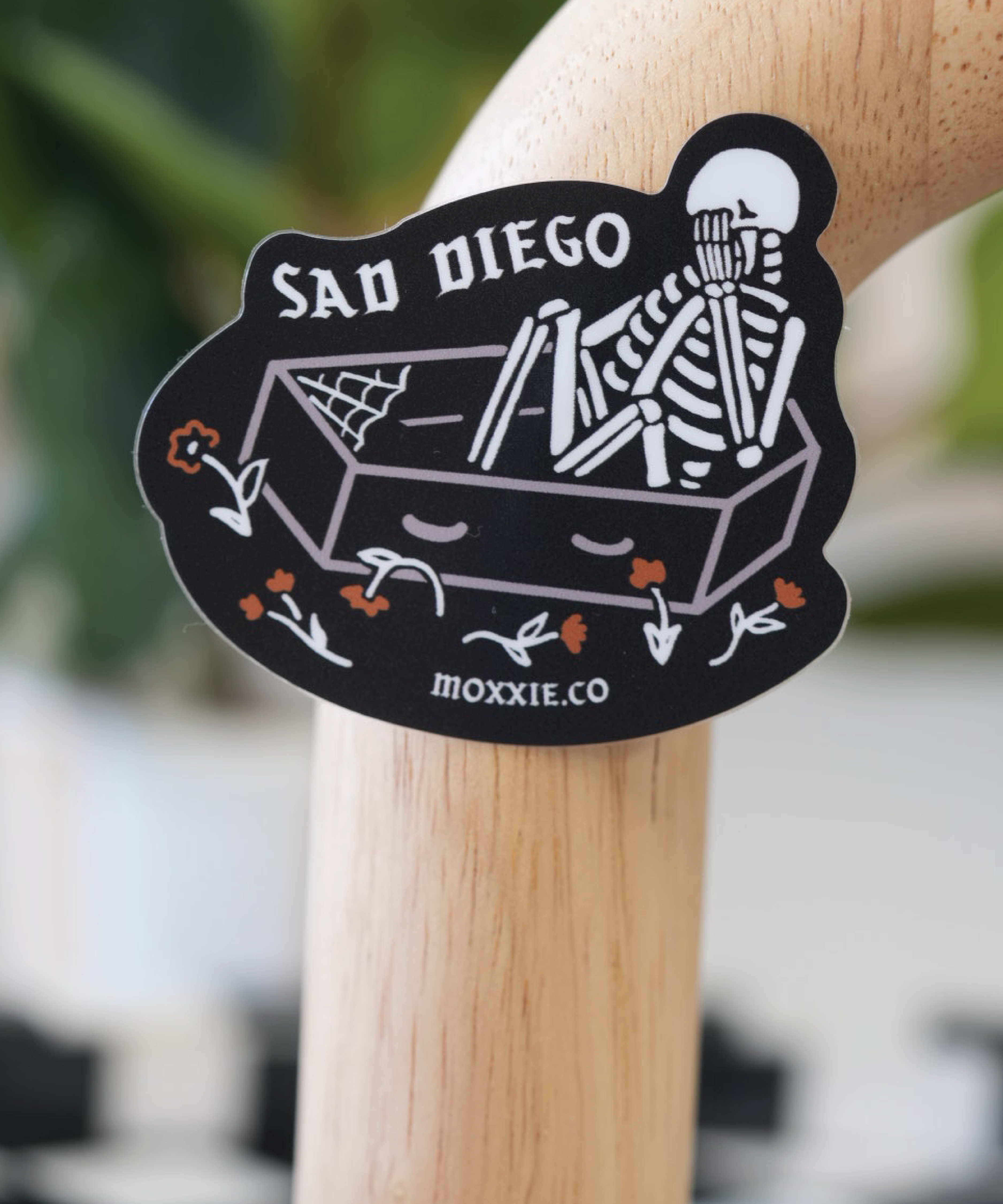 Black 'Sad Diego Gothic' sticker featuring a white skeleton in a coffin, evoking a dark, gothic aesthetic.