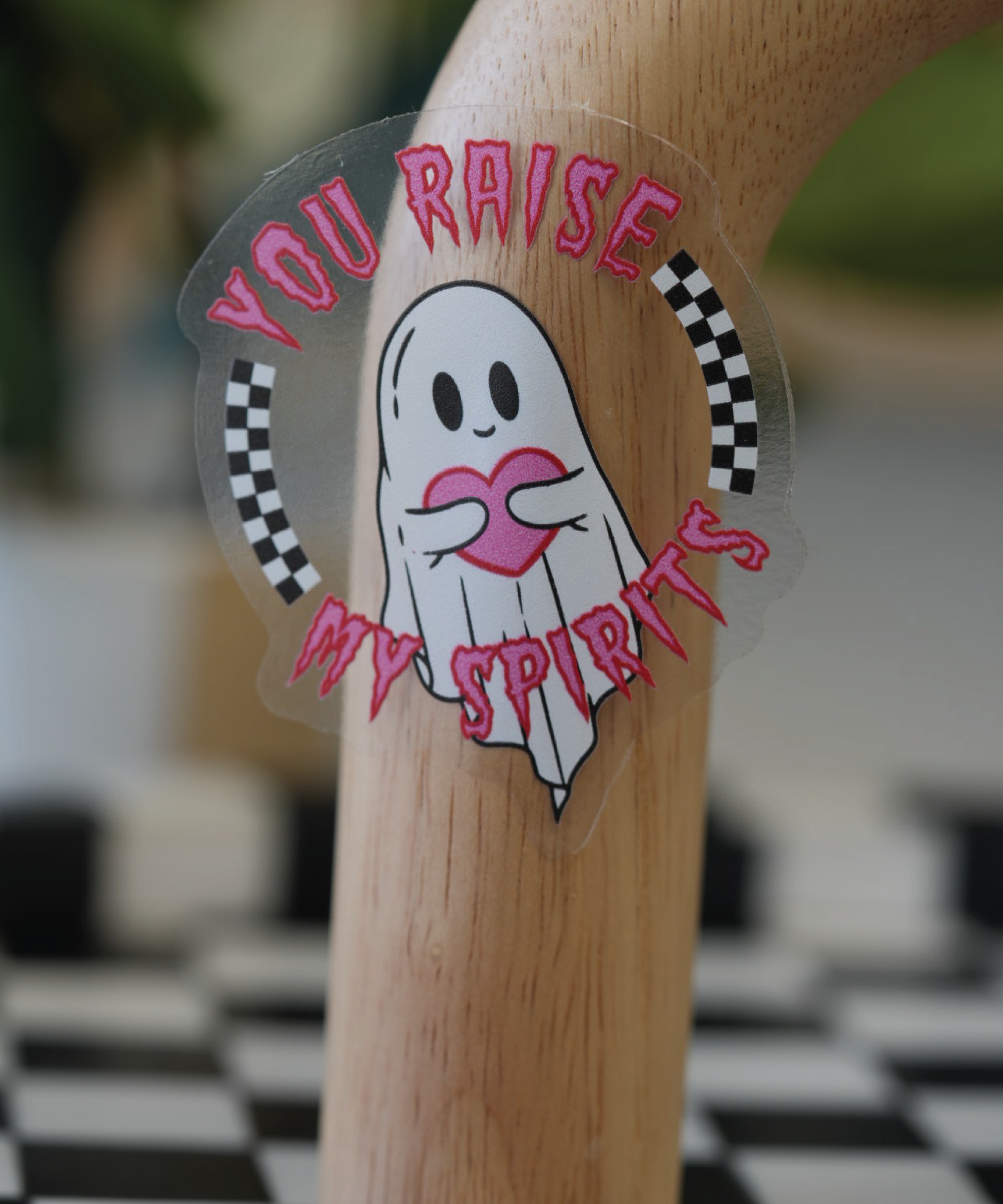 Adorable goth ghost sticker with the phrase 'You Raise My Spirits,' blending spooky vibes with a playful twist on alcohol and spirits, perfect for a sticker collection.
