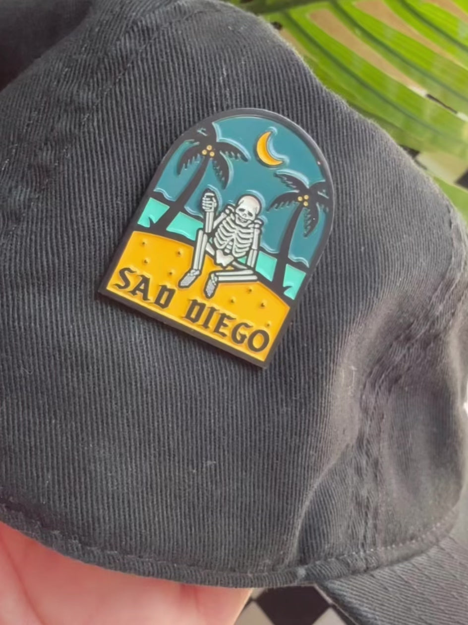 Sad Diego pin featuring an emo skeleton on the beach – perfect for showing off your Pin Game Strong at Emo Night.