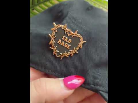 Check out this Sad Babe pin, featuring a barbed copper wire heart and traditional tattoo design, perfect for adding an emo, sad girl vibe to your collection.