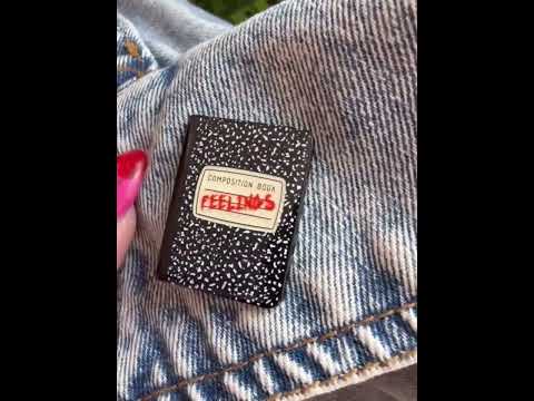 Close-up video of the composition book pin "FEELINGS". Perfect for anyone who loves emo vibes and doodles.