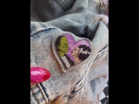Celebrate spooky romance with this Frankenstein + Bride heart-shaped pin, ideal for your Halloween and pin collection
